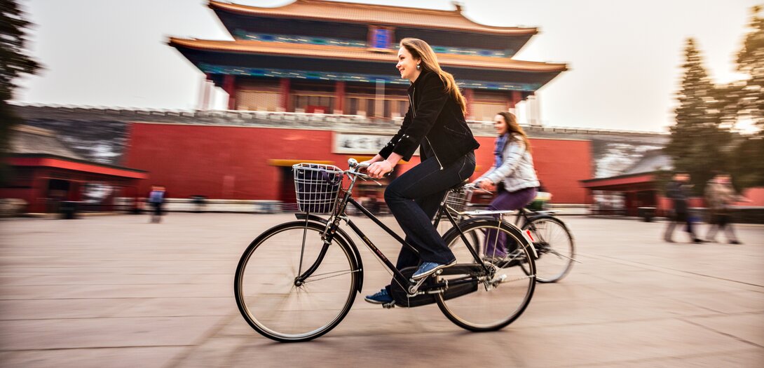 Zwei Radlerinnen nutzen Bikesharing in China. Zwei Radlerinnen nutzen Bikesharing in China.