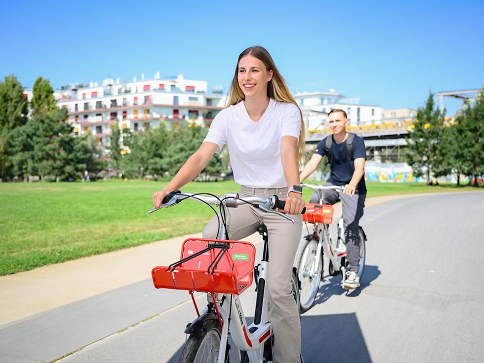 Zwei junge Leute, die in der Start Call a Bike fahren.